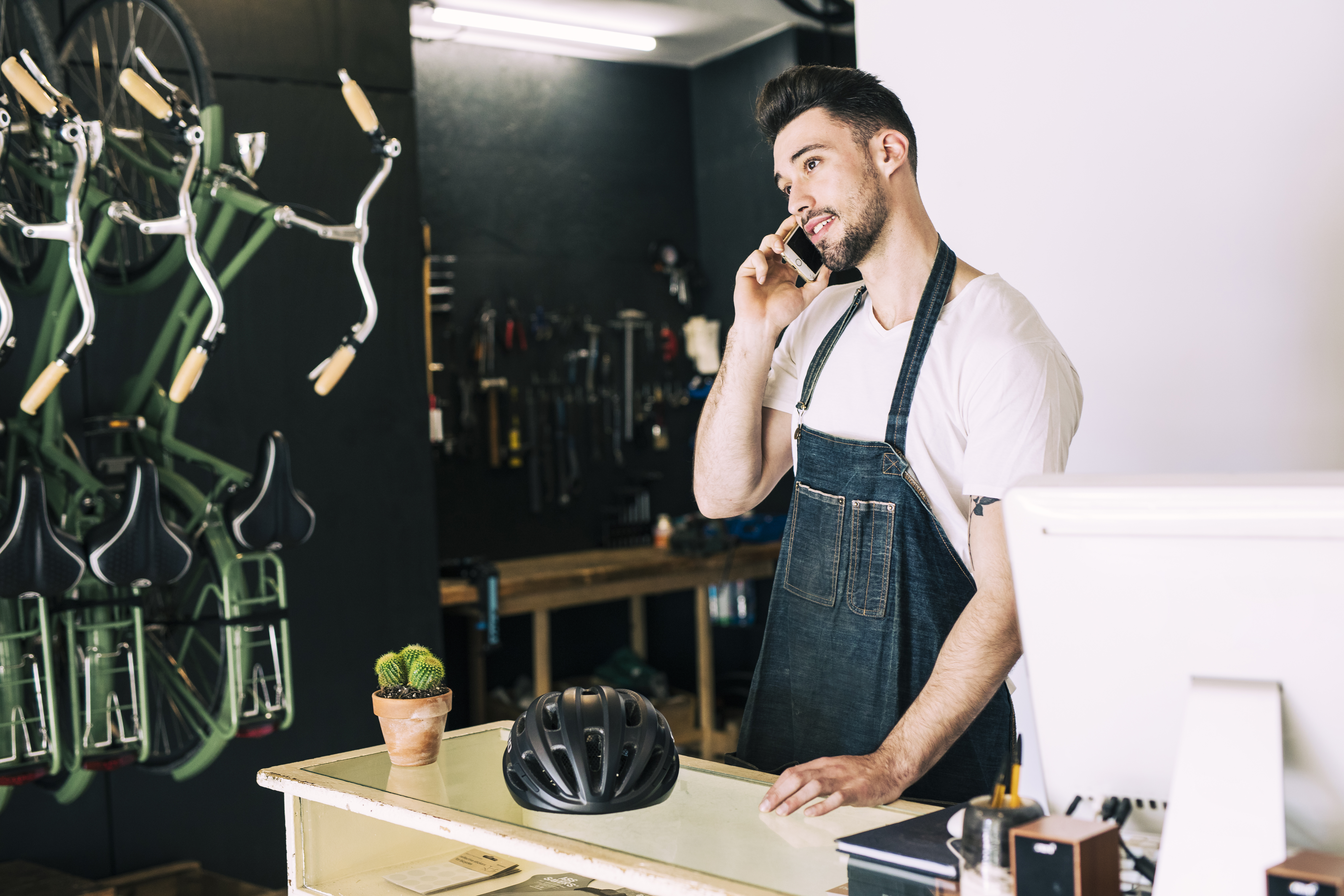 Small business owner speaking on phone in his shop.