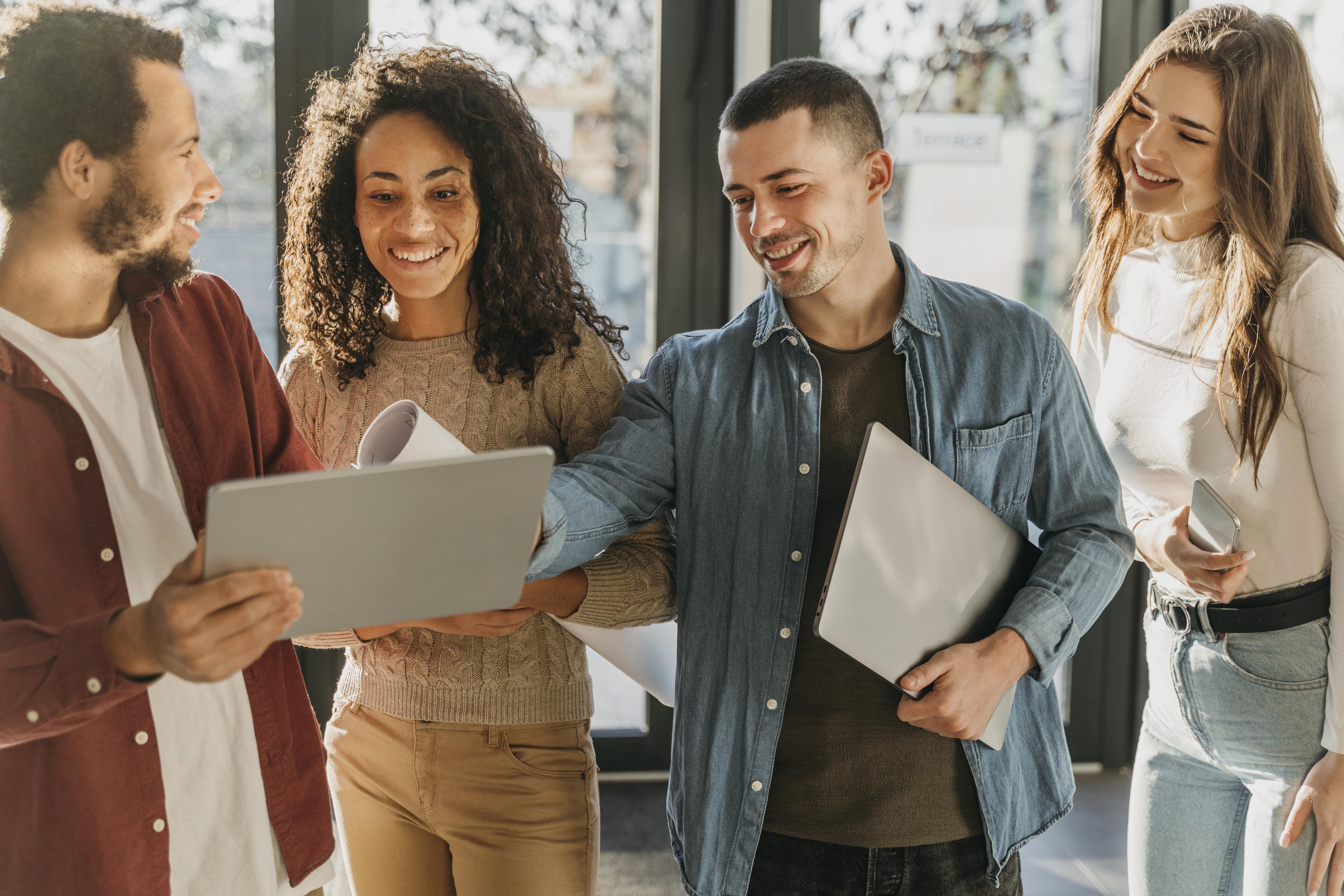 Employees talking around a laptop.