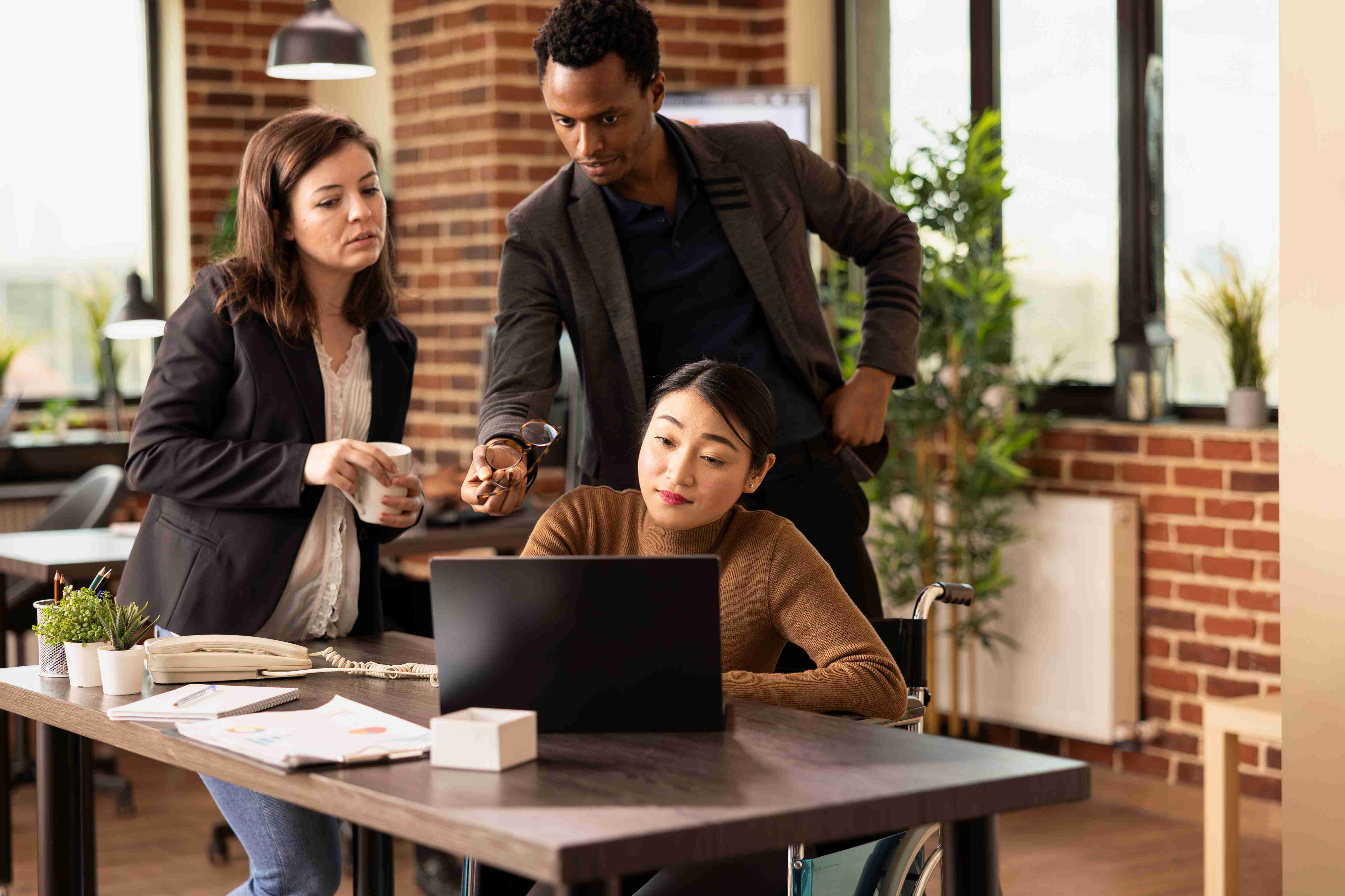 Sales reps looking at a laptop together and making a decision. Image by Freepiks.