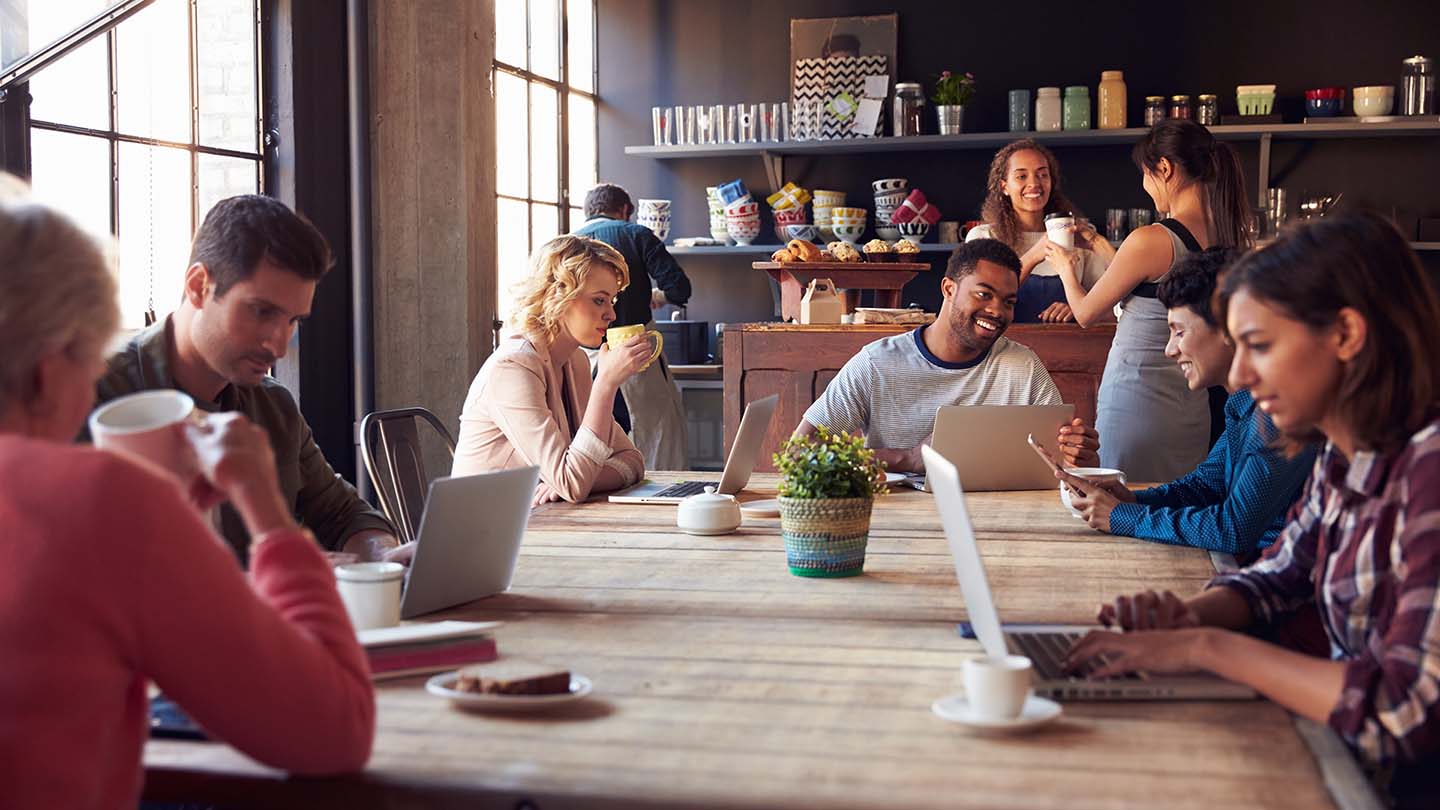A group of people sit around a table laughing