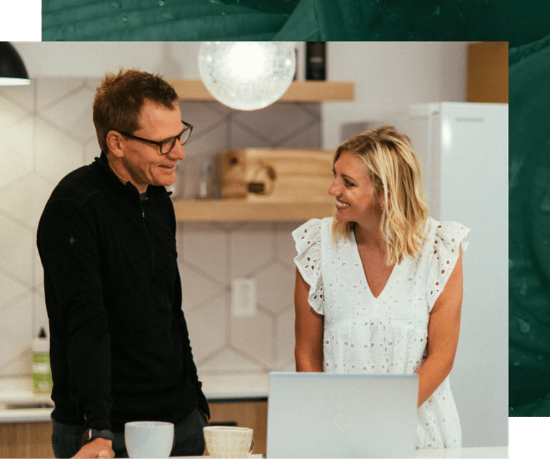 Man and woman on laptop talking over coffee