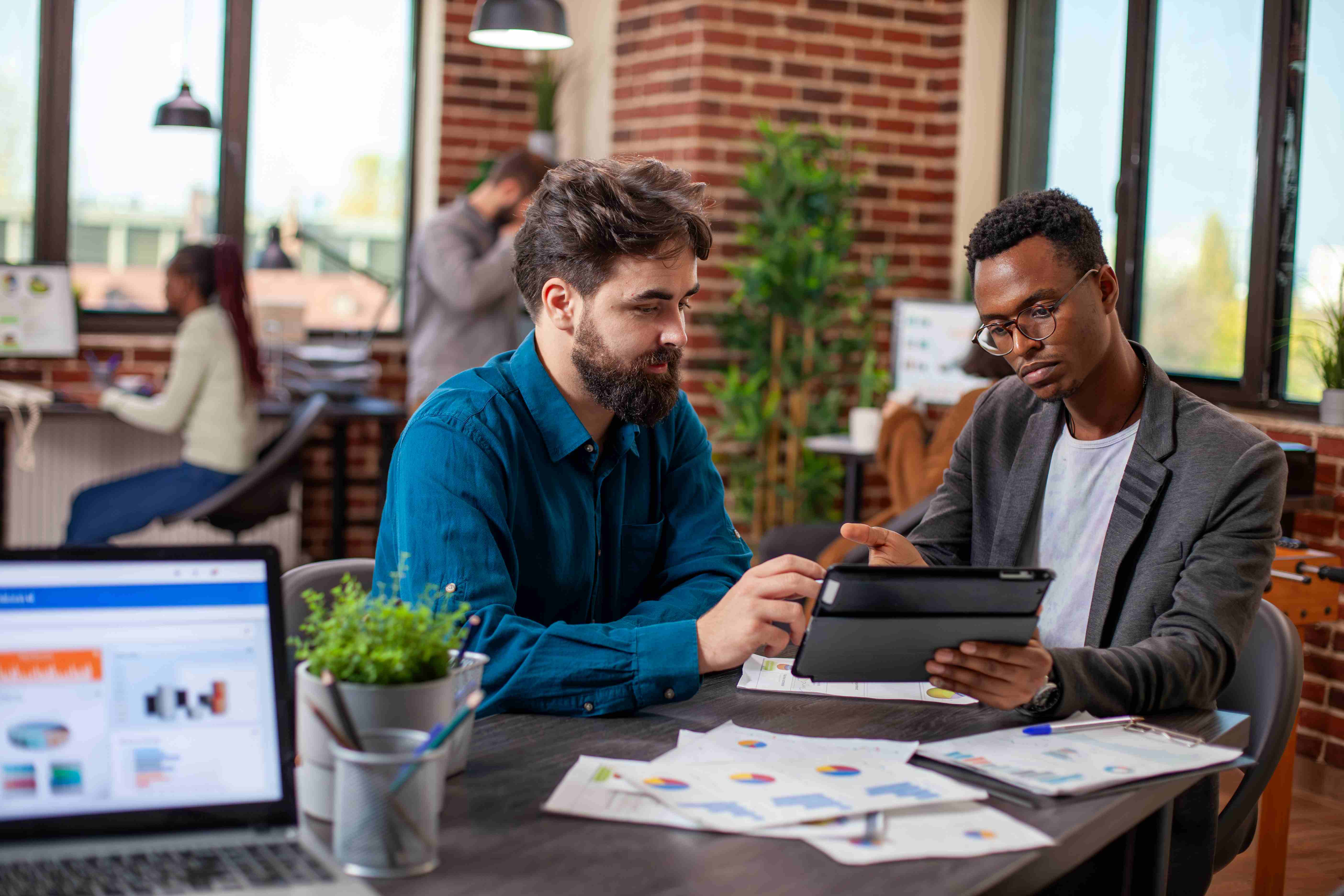 Employees working together at a table, image courtesy of Freepiks.
