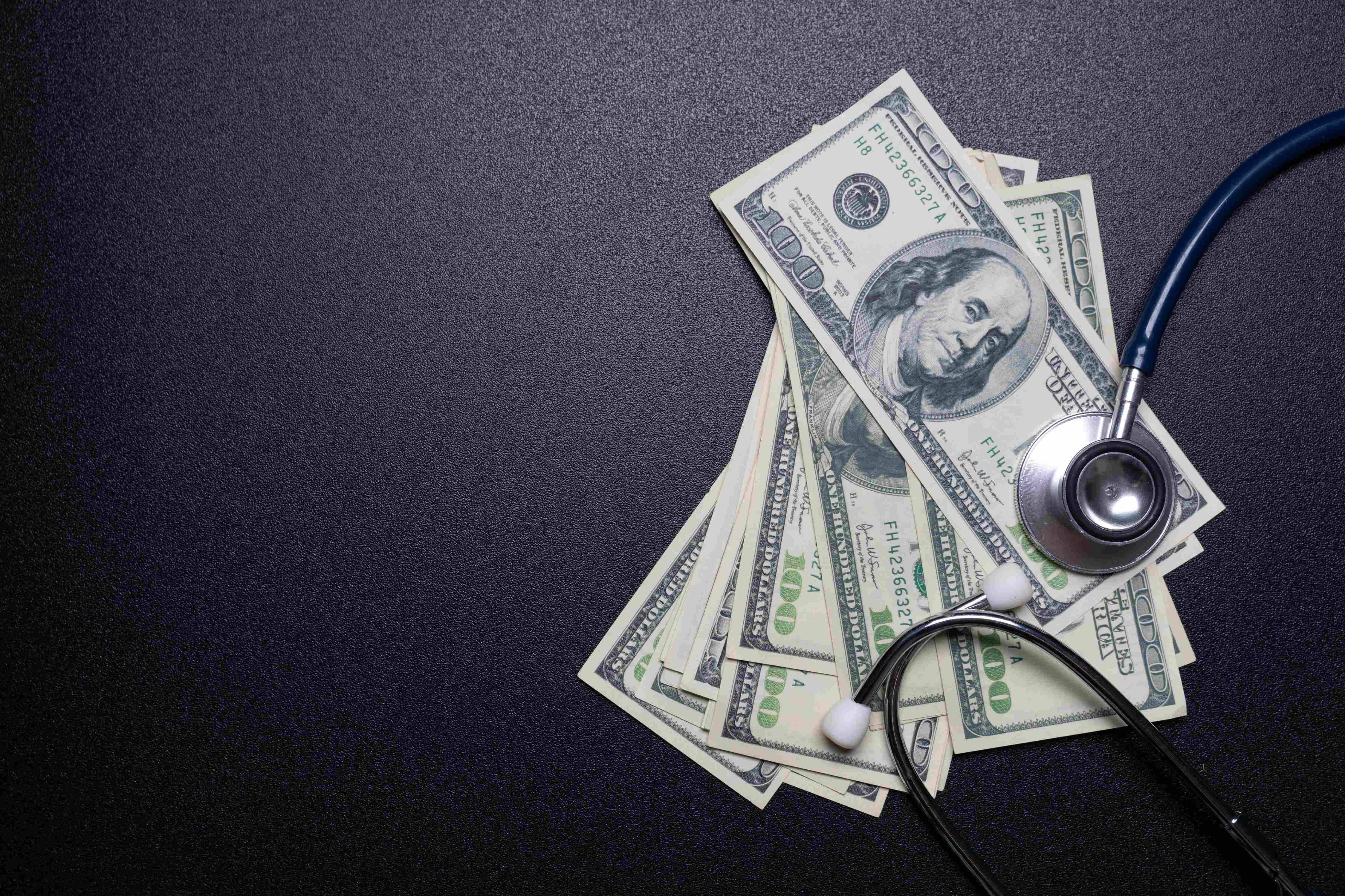 Stethoscope with dollar bills.
